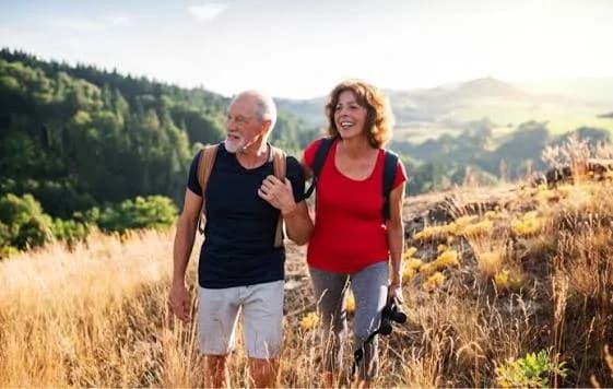 An active senior couple hiking through the hills