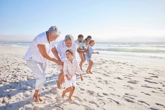 A multi-generational family playing together on the beach