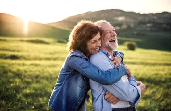 A senior couple laughing together outdoors